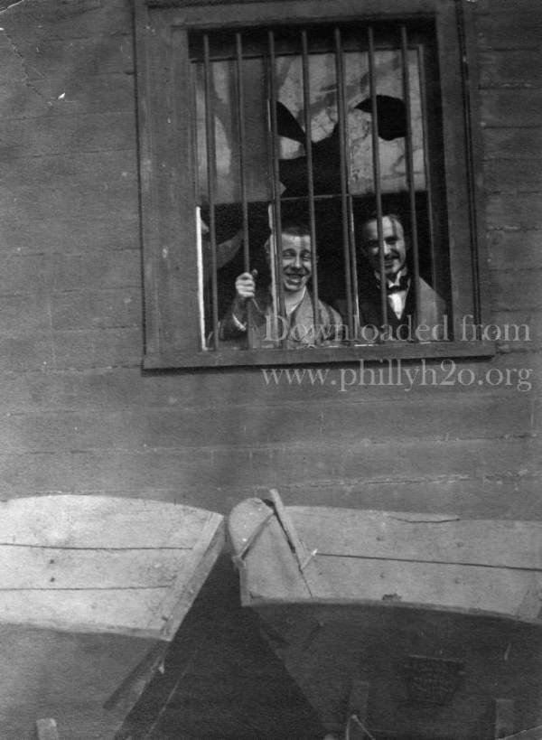 Black-and-white photo of two young men inside a possibly abandoned house