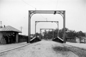 Black and white photo of square archways over a bridge