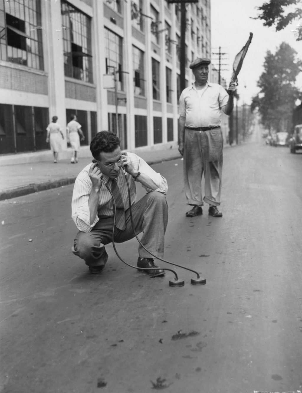 A man in glasses listening to the street through stethoscopes (2012.002.0043)