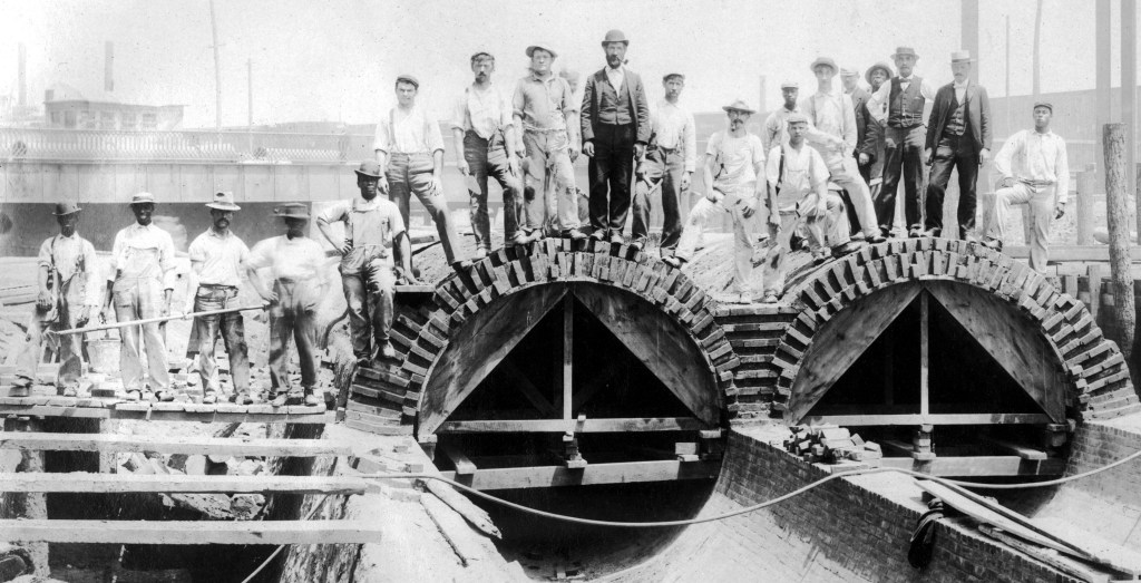 Several people stand atop the Aramingo Sewer during construction, June 7, 1900