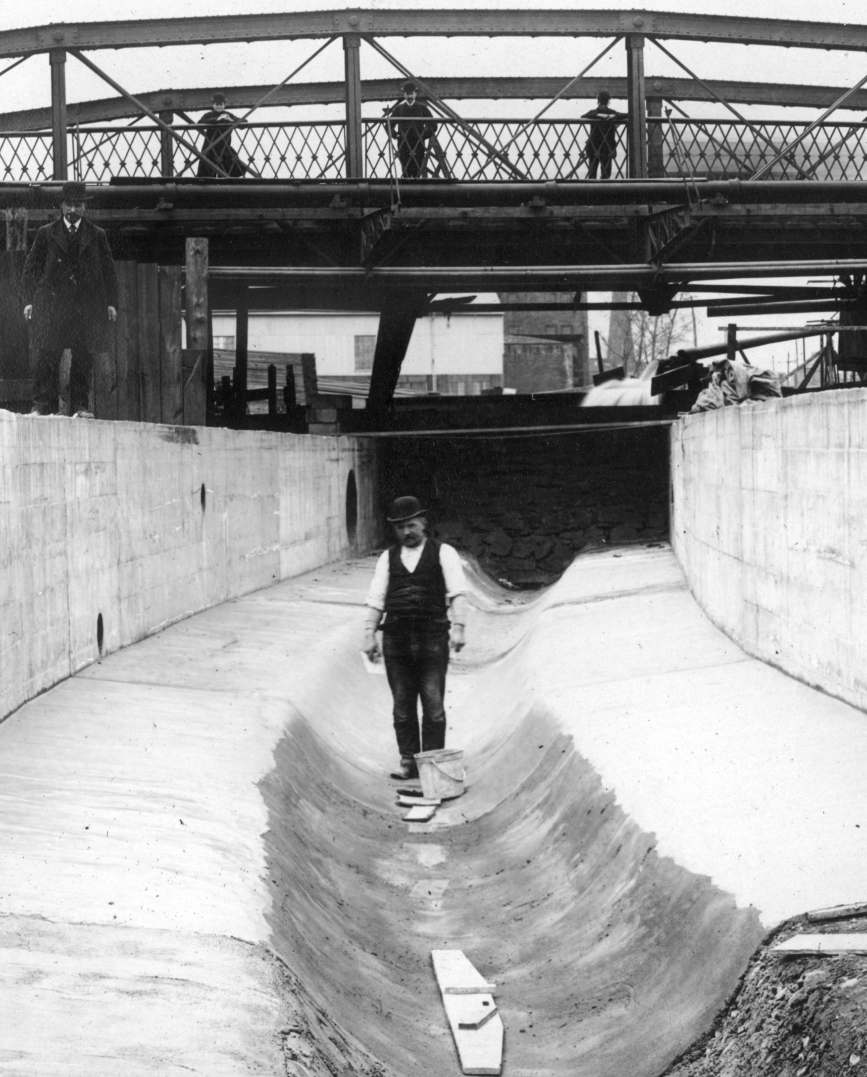Closeup of man walking down channel in Aramingo Sewer, April 13, 1901