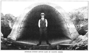 Man standing in front of Bingham Street Sewer, 1921