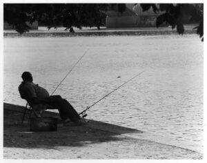 A man fishing from the banks of the Schuylkill River