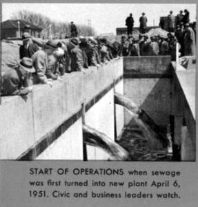 Black and white image of Philadelphia civic and business leaders watching the start of operations at the new Northeast Sewage Treatment Plant, April 6, 1951