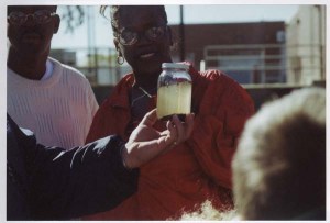 Photo of a woman looking at a jar of raw, untreated sewage