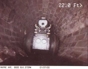 Wheeled robotic sewer crawler in sewer pipe