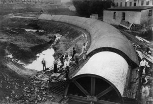 Mill Creek Sewer under construction. Several men standing beside a giant partially constructed sewer pipe.