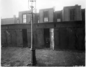 Black-and-white photo of privies, waterless wells used to collect human waste