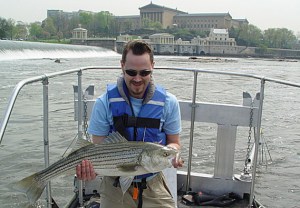 PWD's Jason Cruz holds a striped bass